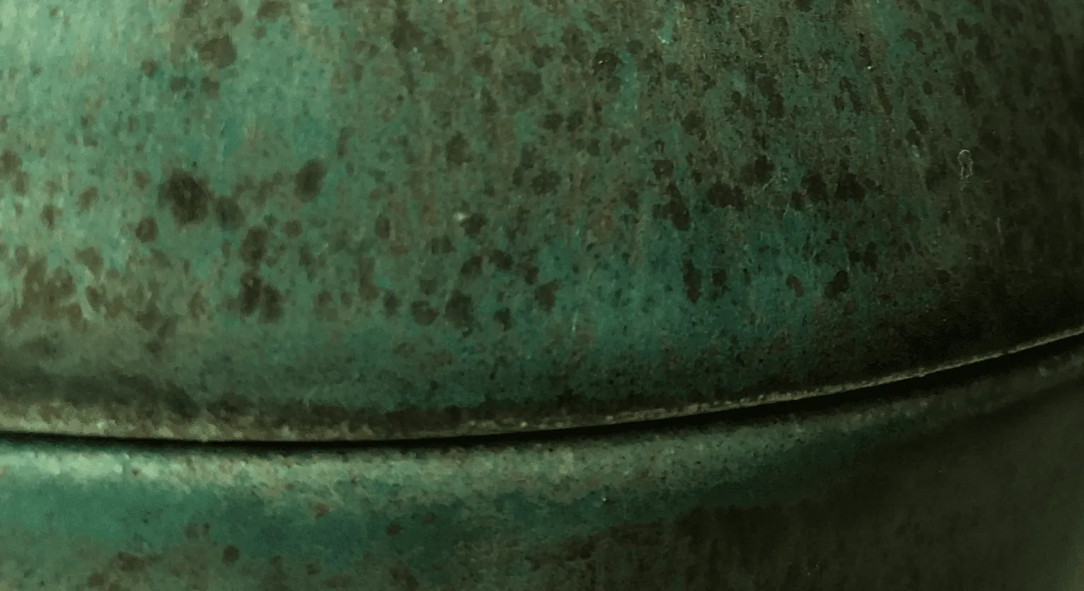Close-up of the speckled green glaze where two pieces meet